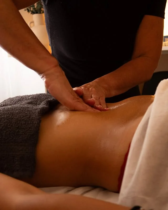 Détail d'un soin de massage dans une lumière tamisée